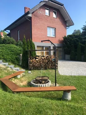 a fire pit in a yard in front of a house at Domek w Gaiku in Limanowa