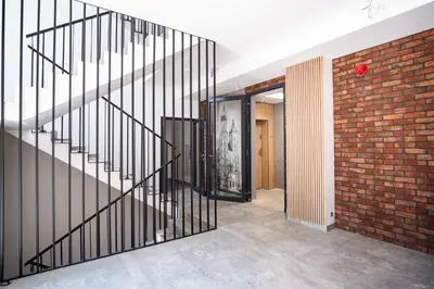 a staircase in a room with a brick wall at Iron Apartments by MB Apartments in Kraków