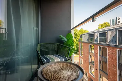 a table and a chair sitting on a balcony at Iron Apartments by MB Apartments in Kraków