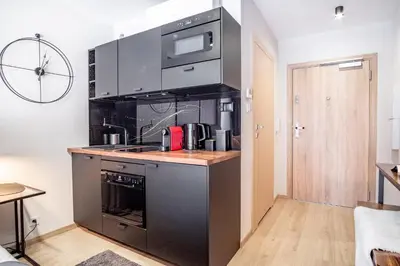 a kitchen with a stove and a microwave at Iron Apartments by MB Apartments in Kraków