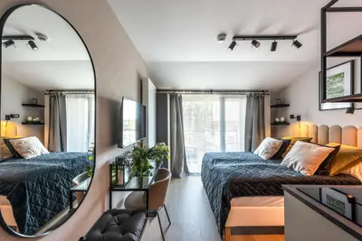 a bedroom with two beds and a mirror at Iron Apartments by MB Apartments in Kraków