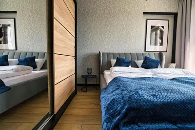a bedroom with two beds and a mirror at Apartament Timi Zator by Housine in Zator
