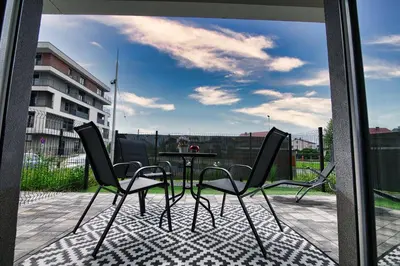 a patio with a table and chairs on a balcony at Apartament Emi Zator by Housine in Zator