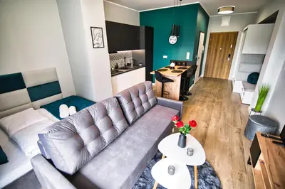 a living room with a couch and a kitchen at Apartament Emi Zator by Housine in Zator