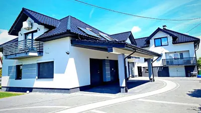 a white house with a black roof at Apartamenty ASLux - Noclegi Energylandia Zator in Zator