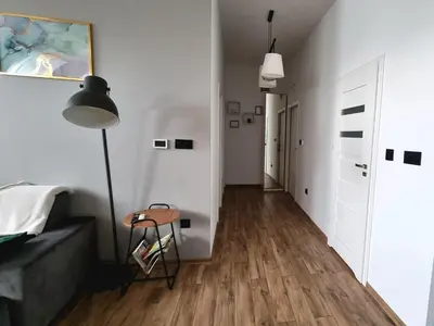 a white room with a table and a lamp at Apartamenty ASLux - Noclegi Energylandia Zator in Zator