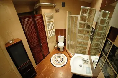 a bathroom with a toilet and a sink at Atena - Pantheon Apartments in Kraków