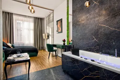 a hotel room with a bathtub and a living room at Apartament czarny z jacuzzi in Kraków