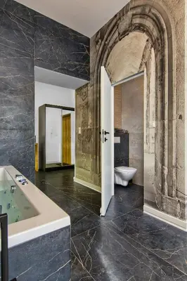 a bathroom with a tub and a toilet in it at Apartament czarny z jacuzzi in Kraków