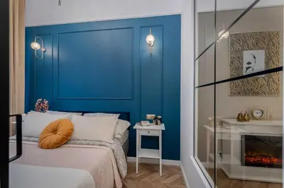 a blue bedroom with a bed and a fireplace at Olver Apartment in Kraków