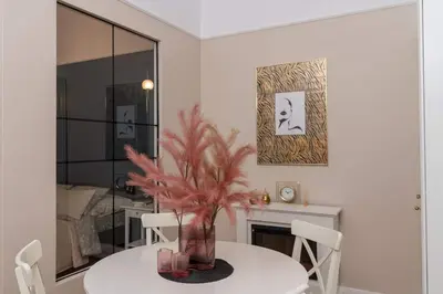 a dining room with a table and a vase with a plant at Olver Apartment in Kraków