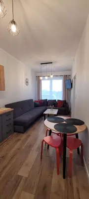 a living room with a couch and a table and chairs at Nest Apartament in Zator