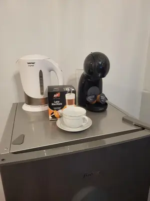 a counter with a coffee maker and a cup on it at Nest Apartament in Zator