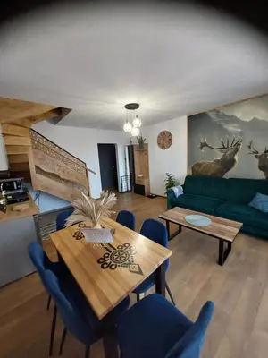 a living room with a green couch and a table at Gorczański Resort Domek w Górach Sauna Jacuzzi in Nowy Targ