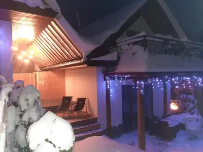 a house with snow and christmas lights on it at Gorczański Resort Domek w Górach Sauna Jacuzzi in Nowy Targ