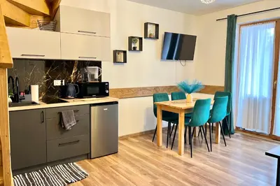a kitchen and dining room with a table and chairs at Gorczański Resort Domek w Górach Sauna Jacuzzi in Nowy Targ