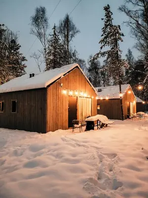 a barn in the snow at night at La Playa Resort & Camp Trzebinia in Trzebinia