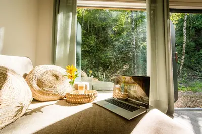 a laptop sitting on a couch in front of a window at La Playa Resort & Camp Trzebinia in Trzebinia