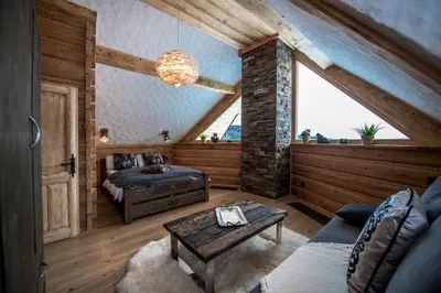 a living room with a bed and a table at Luksusowy domek z jaskinią SPA - Osada Jaworzyny in Tokarnia