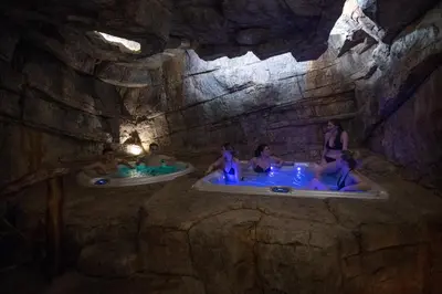 a group of people in tubs in a cave at Luksusowy domek z jaskinią SPA - Osada Jaworzyny in Tokarnia