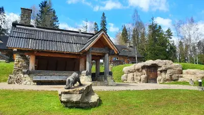 a bear statue sitting on a rock in front of a building at Luksusowy domek z jaskinią SPA - Osada Jaworzyny in Tokarnia