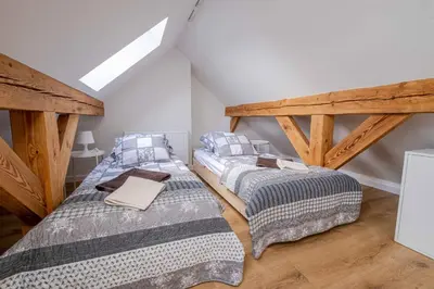 two twin beds in a room with wooden beams at Katowicka Premium Apartment in Kraków