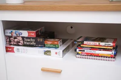 a stack of books sitting on top of a shelf at Katowicka Premium Apartment in Kraków