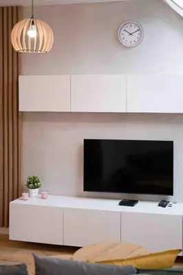 a living room with a tv and a clock on the wall at Katowicka Premium Apartment in Kraków