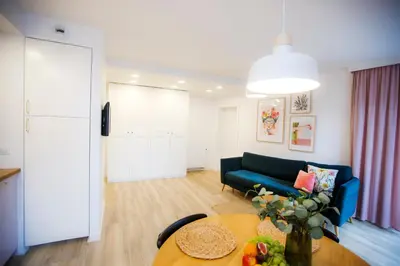 a living room with a blue couch and a table at Bochenka Apartments II in Kraków