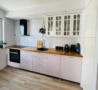 a kitchen with white cabinets and a sink at Bochenka Apartments II in Kraków