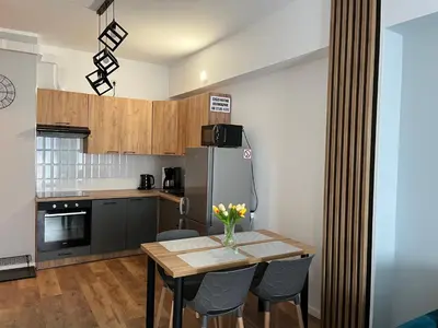 a kitchen with a table with chairs and a refrigerator at Apartament Marko in Zator