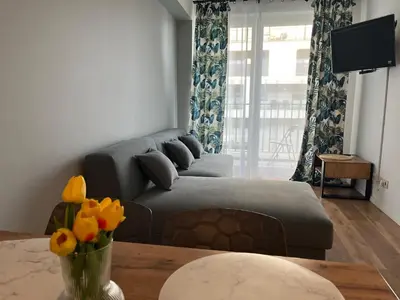 a living room with a couch and a table with flowers at Apartament Marko in Zator