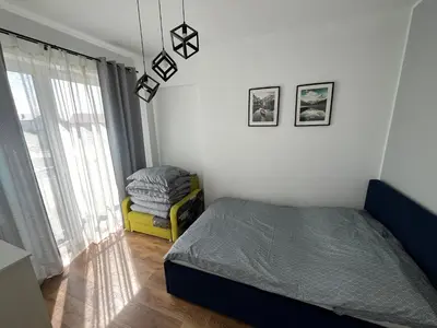 a bedroom with a bed and a chair and a window at Apartament Marko in Zator