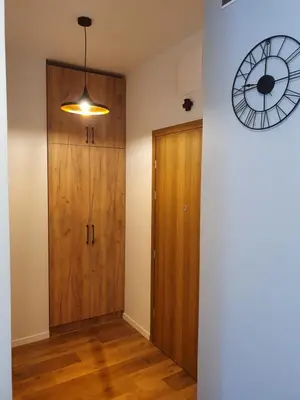 a room with a wooden door and a clock on the wall at Apartament Marko in Zator