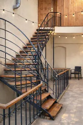 a metal spiral staircase in a building with lights at Urban Nest Apartments Szewska 21-19 in Kraków