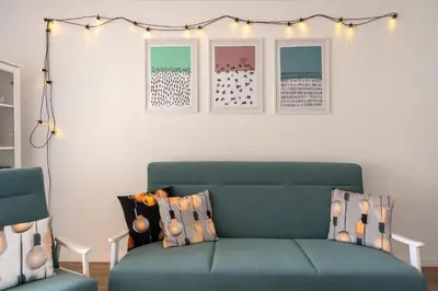 a living room with a green couch and lights at Apartament Nad Różami in Oświęcim