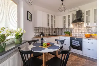 a kitchen with a table and chairs in a kitchen at Apartament Nad Różami in Oświęcim