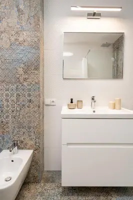 a white bathroom with a sink and a mirror at Apartament Nad Różami in Oświęcim