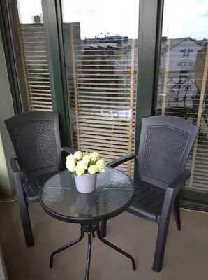 two chairs and a table with a bowl of flowers on it at Apartament Nad Różami in Oświęcim