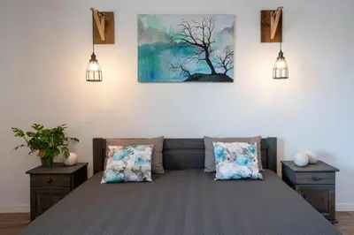 a bedroom with a bed with two pillows and two lights at Apartament Nad Różami in Oświęcim