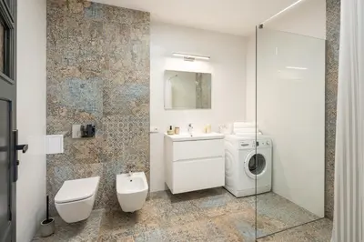 a bathroom with a toilet sink and a washing machine at Apartament Nad Różami in Oświęcim