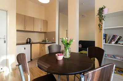 a dining room table with a vase of flowers on it at Negroni Apartments Dajwor in Kraków