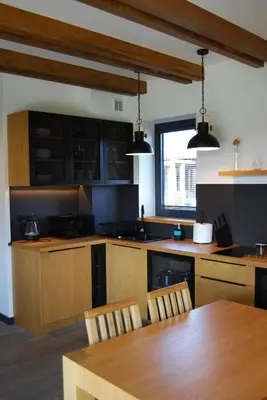 a kitchen with a wooden table and a tableasteryasteryasteryasteryasteryasteryastery at Domki Kuter Port in Gdów