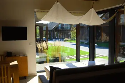 a living room with a large window with a view of a yard at Domki Kuter Port in Gdów