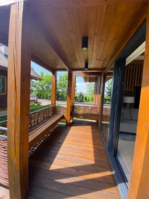 a wooden walkway leading to the porch of a house at Domki Kuter Port in Gdów
