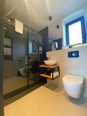 a bathroom with a toilet and a sink and a shower at Domki Kuter Port in Gdów