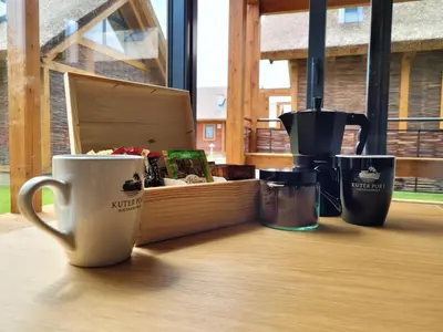 a table with coffee cups and a box on it at Domki Kuter Port in Gdów