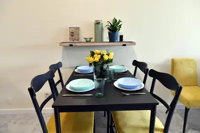 a black table with blue plates and yellow flowers on it at Ach To Tu! Apartament Zator in Zator