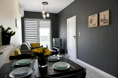 a living room with a table with plates and flowers on it at Ach To Tu! Apartament Zator in Zator