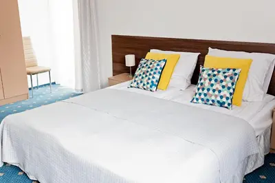 a large white bed with two pillows on it at Janda Resort & Conference in Mszana Dolna